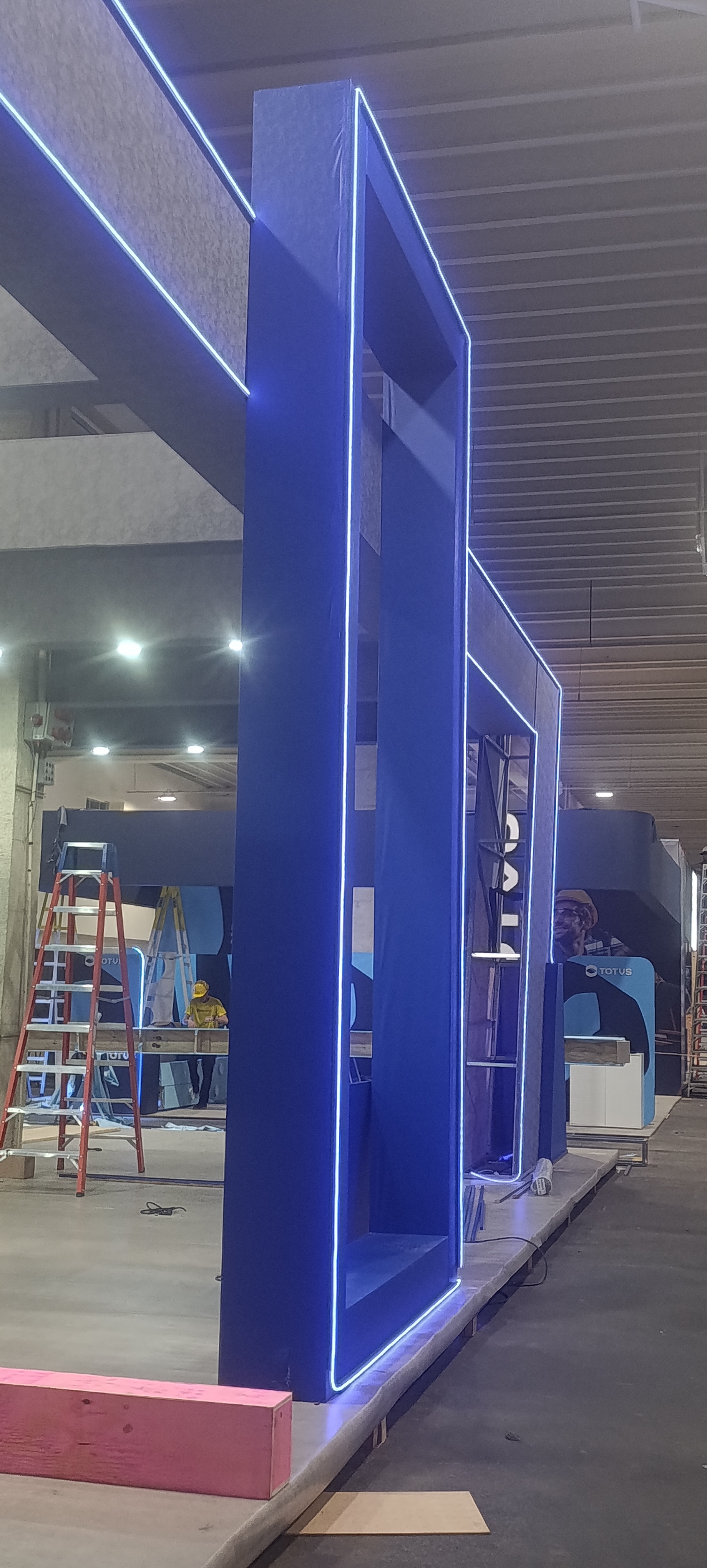 Fachada de estande com neon de LED laranja e letreiro iluminado